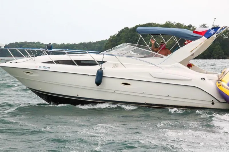 Slide: The Image of 2002 Bayliner 3055 Ciera cruising on a lake with lush green shoreline. - 21