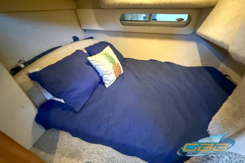 Slide: The Image of Cozy cabin interior of 2002 Bayliner 3055 Ciera with blue bedding and pineapple pillow. - 7