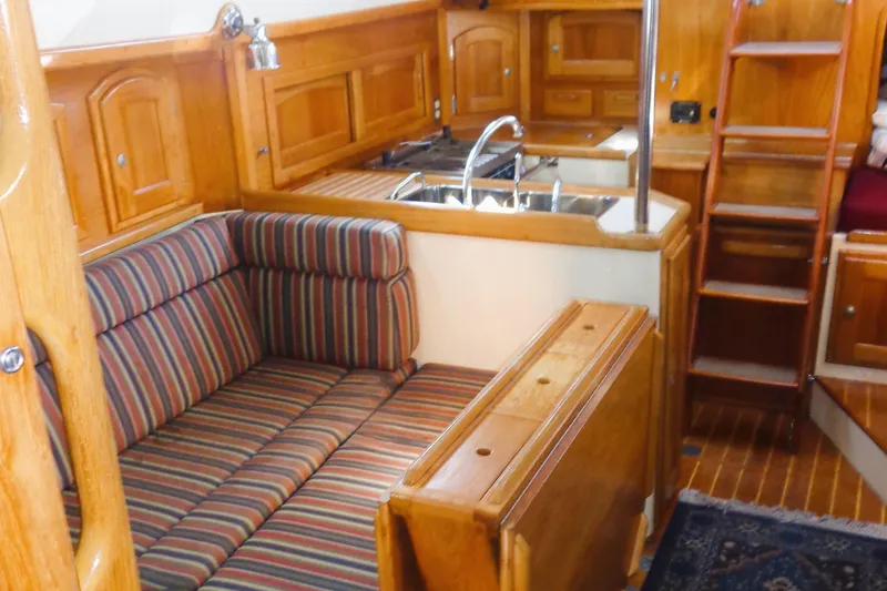Slide: The Image of Interior of 1997 Pacific Seacraft 37 sailboat with striped seating and wooden cabinetry. - 4
