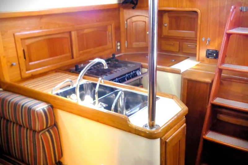 Slide: The Image of Interior of 1997 Pacific Seacraft 37 sailboat, featuring a wooden galley with sink and stove. - 5