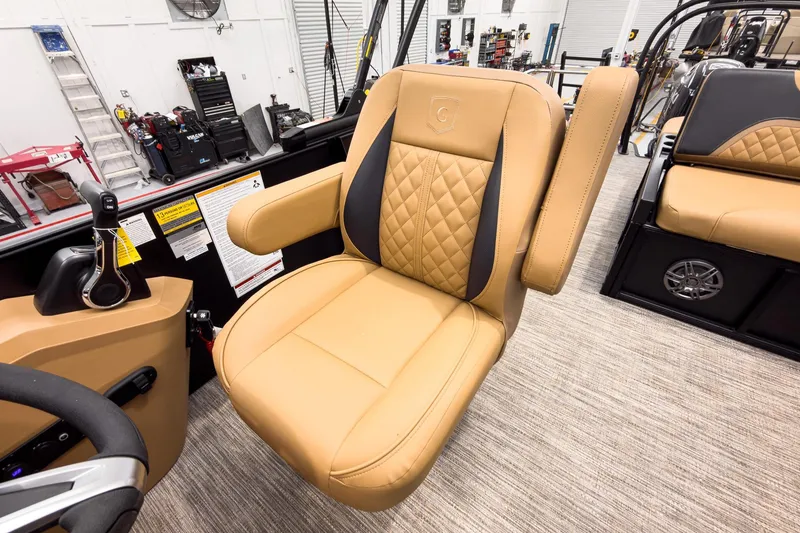 Slide: The Image of Luxurious tan seating on 2026 Godfrey Sweetwater 22' Tritoon boat in a workshop setting. - 15