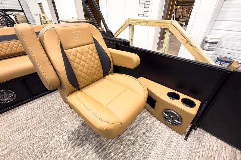 Slide: The Image of Luxurious tan seating on 2026 Godfrey Sweetwater 22' Tritoon, featuring cup holders and speaker. - 16
