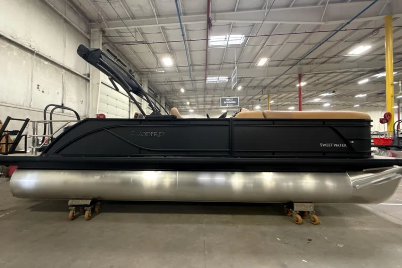 Slide: The Image of 2026 Godfrey Sweetwater 22' Tritoon boat in warehouse setting. - 27