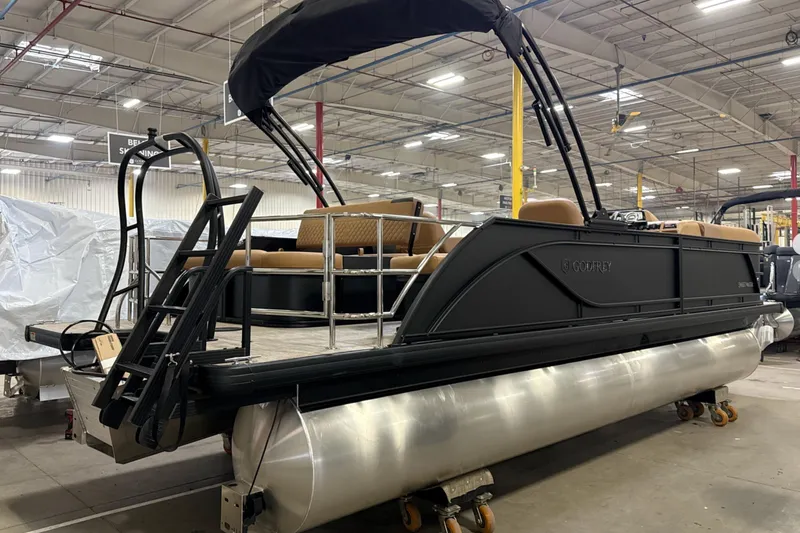 Slide: The Image of 2026 Godfrey Sweetwater 22' Tritoon boat in a warehouse, featuring a single flip lounge. - 28