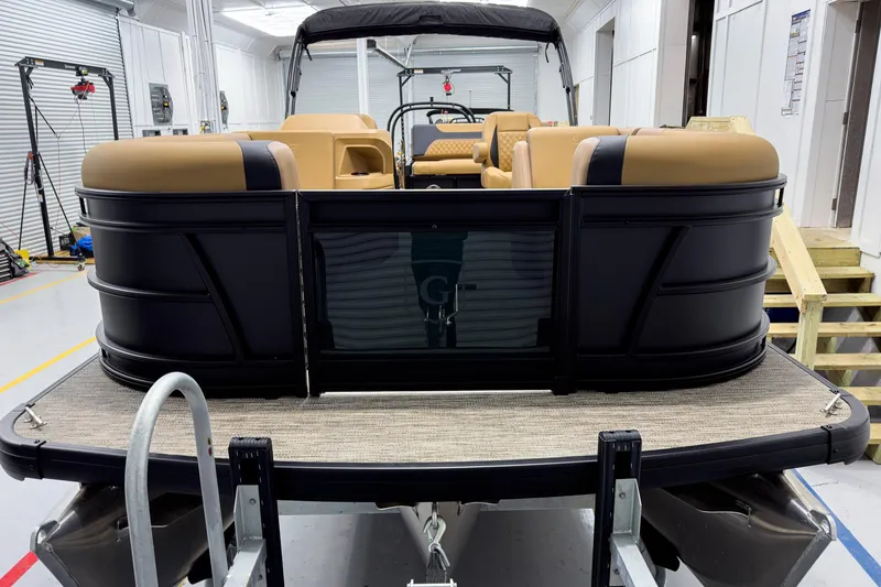 Slide: The Image of 2026 Godfrey Sweetwater 22' Tritoon with tan seating in a showroom. - 3