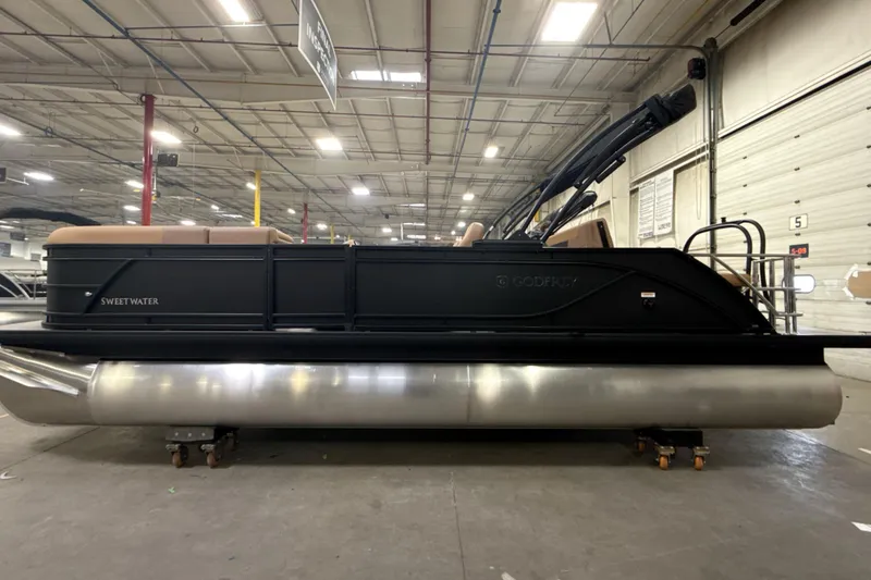 Slide: The Image of 2026 Godfrey Sweetwater 22' Tritoon boat in a warehouse setting. - 31