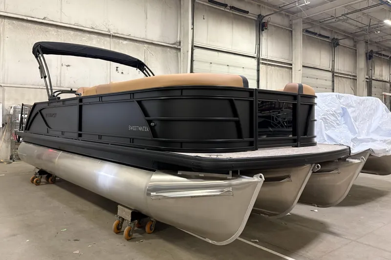 Slide: The Image of 2026 Godfrey Sweetwater 22' Tritoon boat in warehouse, featuring sleek black design. - 34