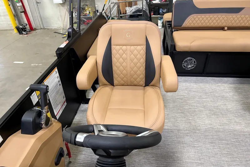 Slide: The Image of Captain's chair in 2026 Godfrey Sweetwater 22' Tritoon, featuring tan upholstery and steering wheel. - 39
