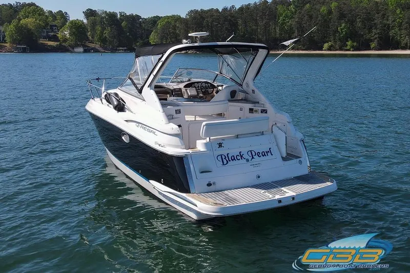 Slide: The Image of 2006 Regal 3060 Window Express boat named "Black Pearl" on a serene lake. - 11