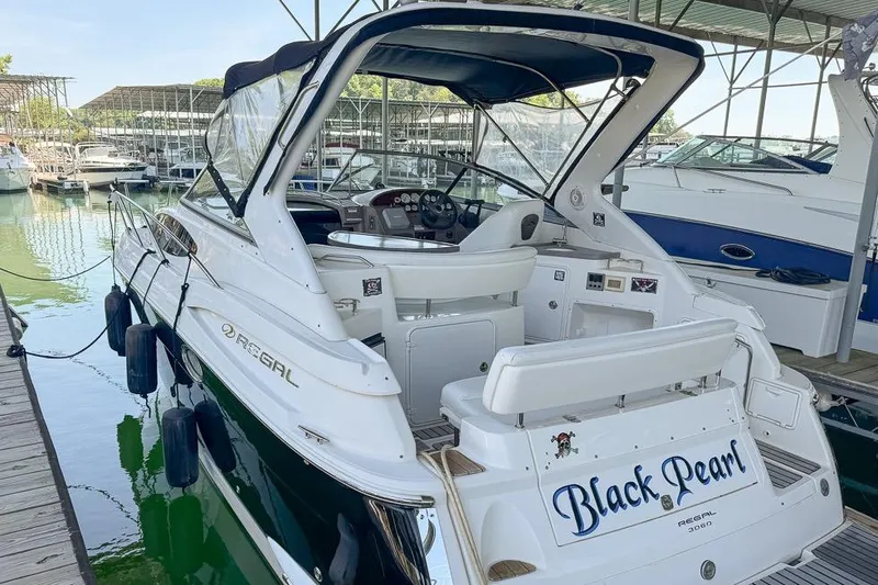 Slide: The Image of 2006 Regal 3060 Window Express boat named "Black Pearl" docked in a marina. - 12