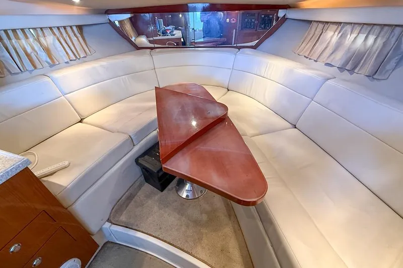 Slide: The Image of Interior of 2006 Regal 3060 Window Express yacht with white seating and wooden table. - 13