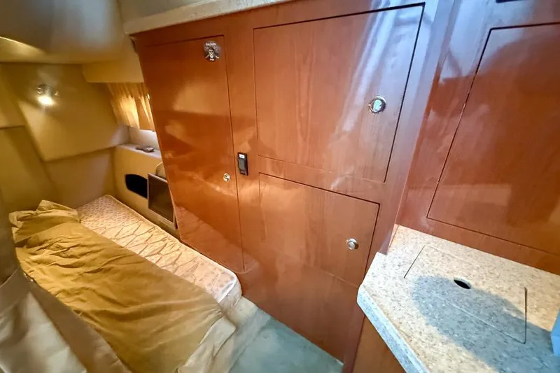 Slide: The Image of Interior of 2006 Regal 3060 Window Express boat with wood cabinetry and cozy sleeping area. - 15