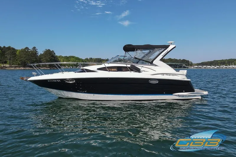 Slide: The Image of 2006 Regal 3060 Window Express boat on a serene lake with clear skies. - 2