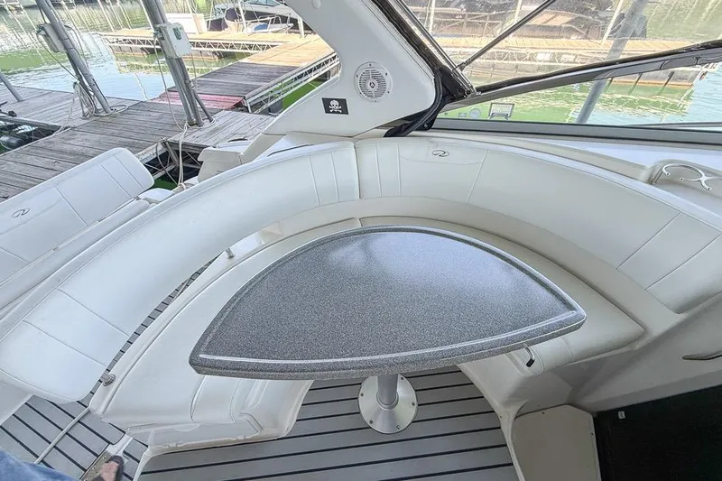 Slide: The Image of Interior of a 2006 Regal 3060 Window Express boat with white seating and a table. - 21
