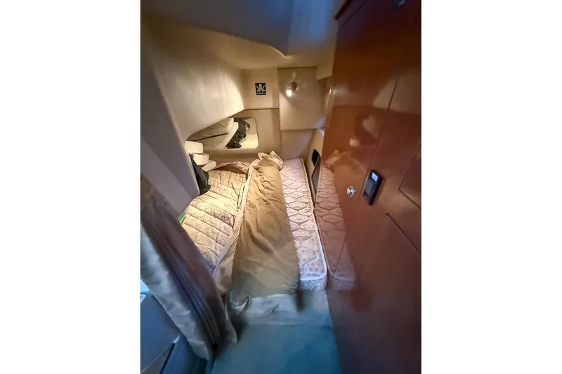 Slide: The Image of Interior cabin of 2006 Regal 3060 Window Express boat, featuring cozy sleeping area. - 25