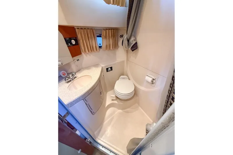 Slide: The Image of Compact bathroom in a 2006 Regal 3060 Window Express boat, featuring sink and toilet. - 26