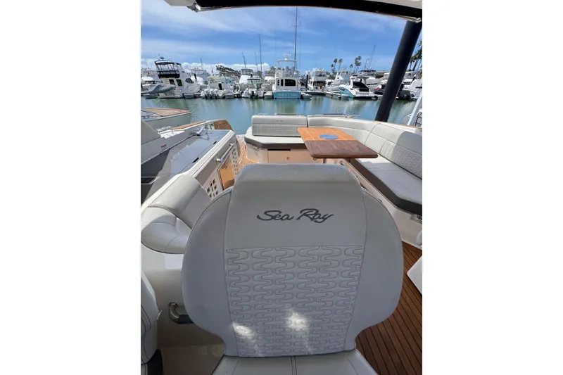 Slide: The Image of 2021 Sea Ray SLX 400 boat interior with seating and table, docked at a marina. - 29