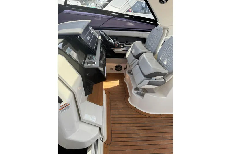 Slide: The Image of 2021 Sea Ray SLX 400 helm with dual seats and modern dashboard on teak flooring. - 30