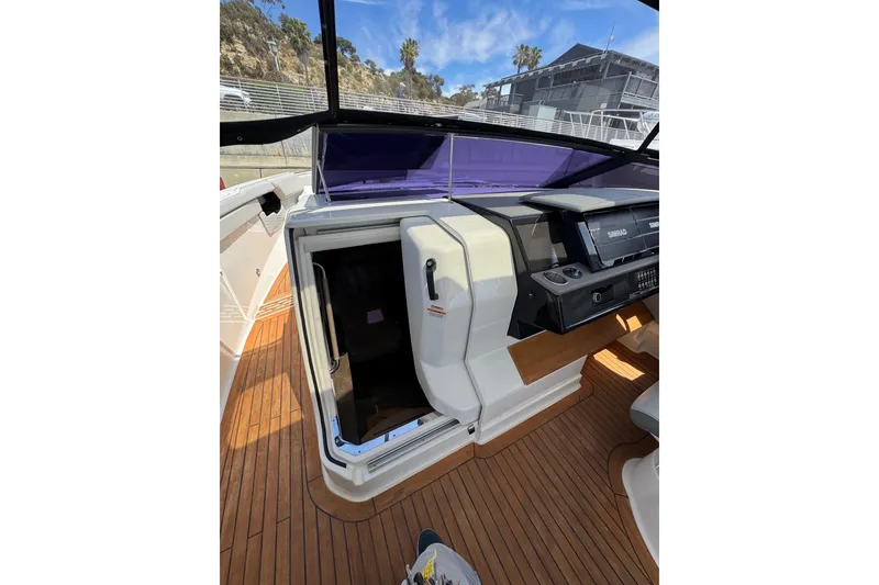 Slide: The Image of 2021 Sea Ray SLX 400 boat interior with open cabin door and modern dashboard. - 36