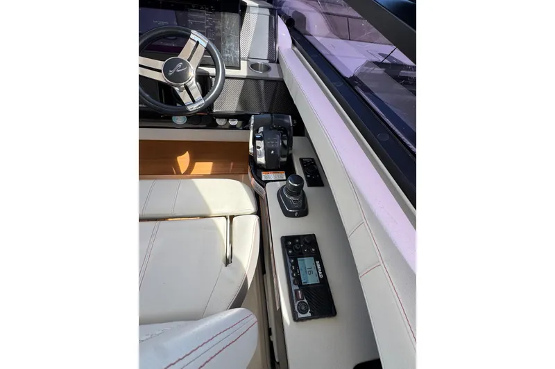 Slide: The Image of 2021 Sea Ray SLX 400 helm with steering wheel, controls, and navigation equipment. - 37