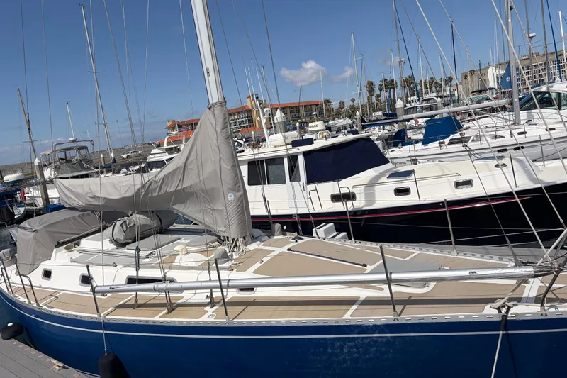 The Image of 1986 Nordic 44 sailboat docked in a marina, surrounded by other boats. - 0