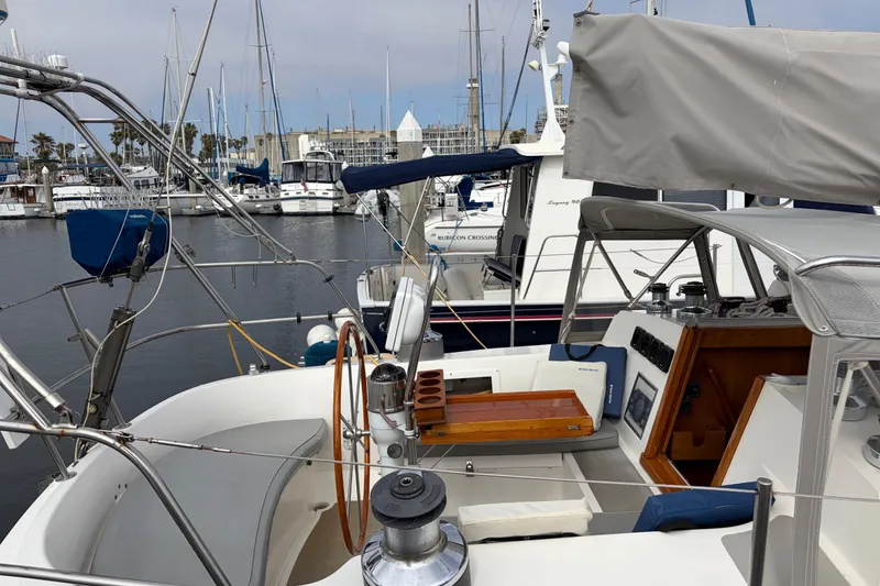 Slide: The Image of Sailboat docked in marina, Nordic 44 model, 1986, with visible cockpit and steering wheel. - 10