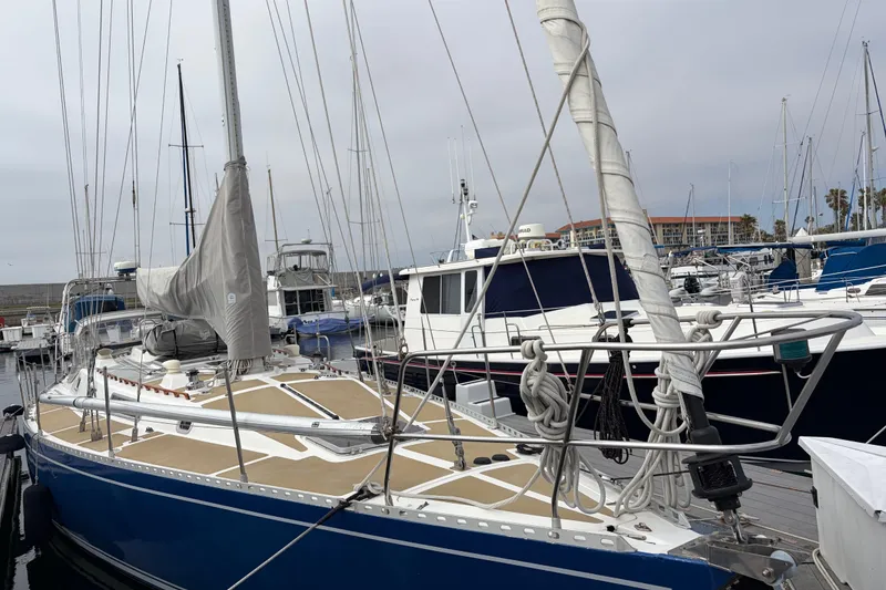 Slide: The Image of Sailboat Nordic 44, 1986 model, docked at marina with covered cockpit area. - 11