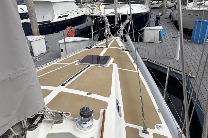 Slide: The Image of 1986 Nordic 44 sailboat deck at marina, featuring winch and rigging. - 13