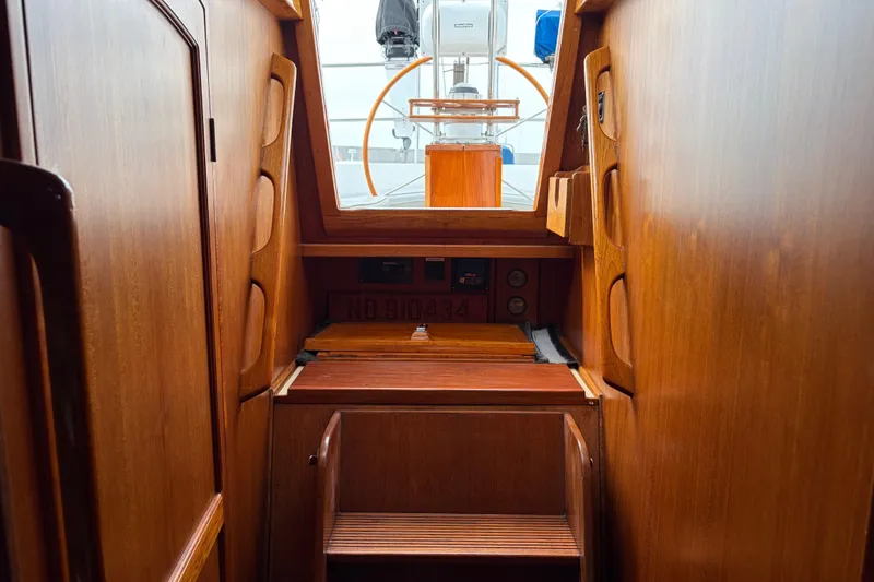 Slide: The Image of Cream-colored sofa in a 1986 Nordic 44 boat interior with wooden paneling. - 29