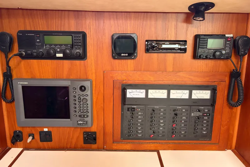 Slide: The Image of Cozy cabin interior of 1986 Nordic 44 sailboat with wooden paneling and blue bedding. - 31