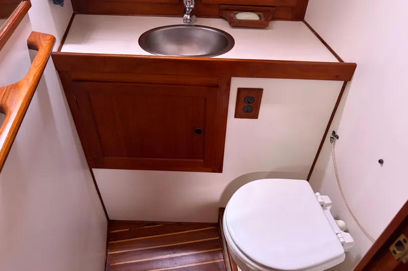 Slide: The Image of Compact 1986 Nordic 44 boat bathroom with wooden accents and stainless steel sink. - 34