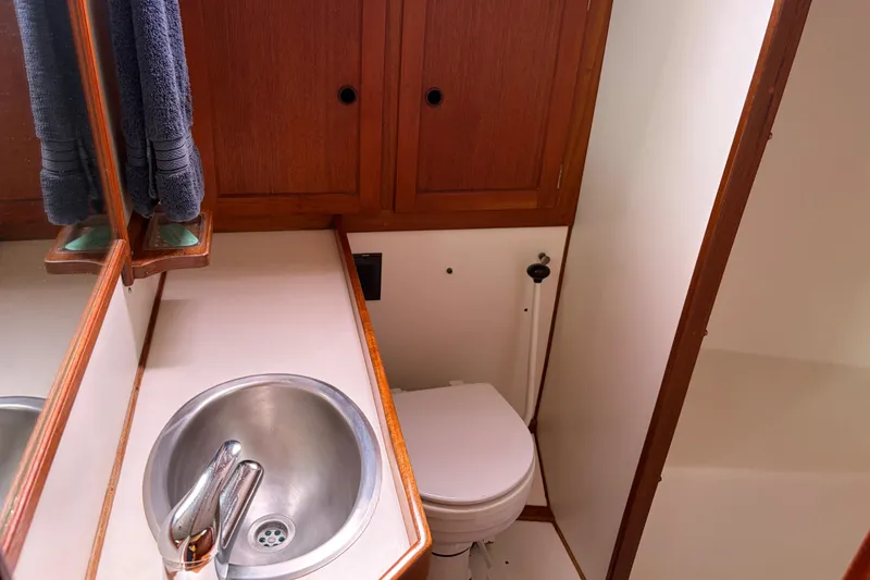 Slide: The Image of Compact bathroom in 1986 Nordic 44 boat with sink, toilet, and wooden cabinetry. - 36