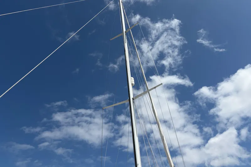 Slide: The Image of Tall mast of 1986 Nordic 44 sailboat against a blue sky with clouds. - 8