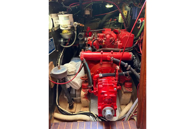 Slide: The Image of Engine room of a 1986 Nordic 44 sailboat, featuring a red marine engine. - 9