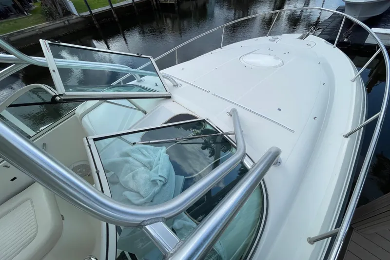 Slide: The Image of 2006 Hydra-Sports Vector 2900 VX boat deck with open windshield, docked by water. - 24
