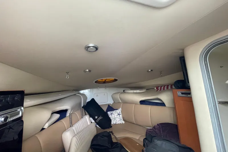 Slide: The Image of Interior cabin of a 2006 Hydra-Sports Vector 2900 VX boat, featuring beige seating and storage. - 39