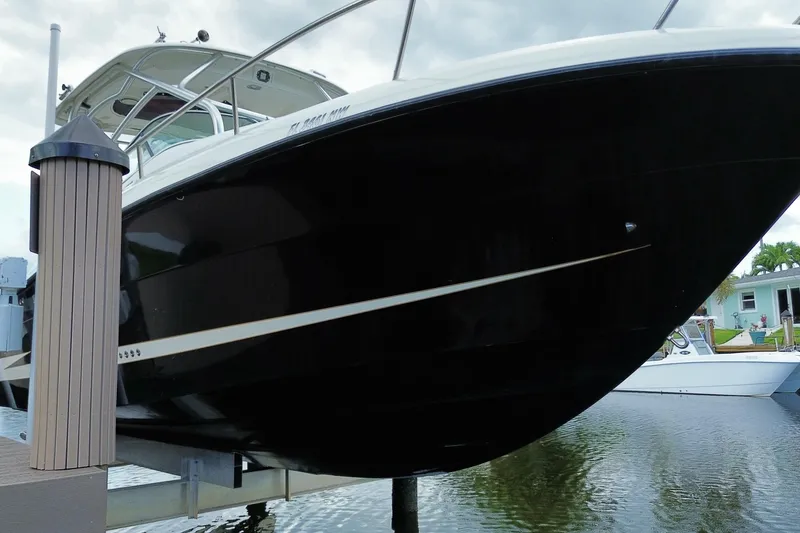 Slide: The Image of 2006 Hydra-Sports Vector 2900 VX boat docked, showcasing sleek black hull design. - 4