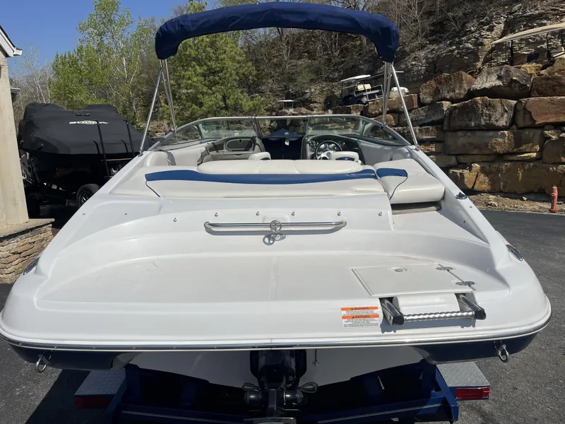 Slide: The Image of 2008 Crownline 23 SS boat with blue cover, parked on asphalt. - 19