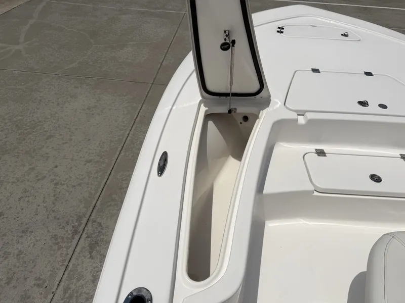 Slide: The Image of 2026 Tidewater 2110BMT boat with open storage compartment on concrete surface. - 19