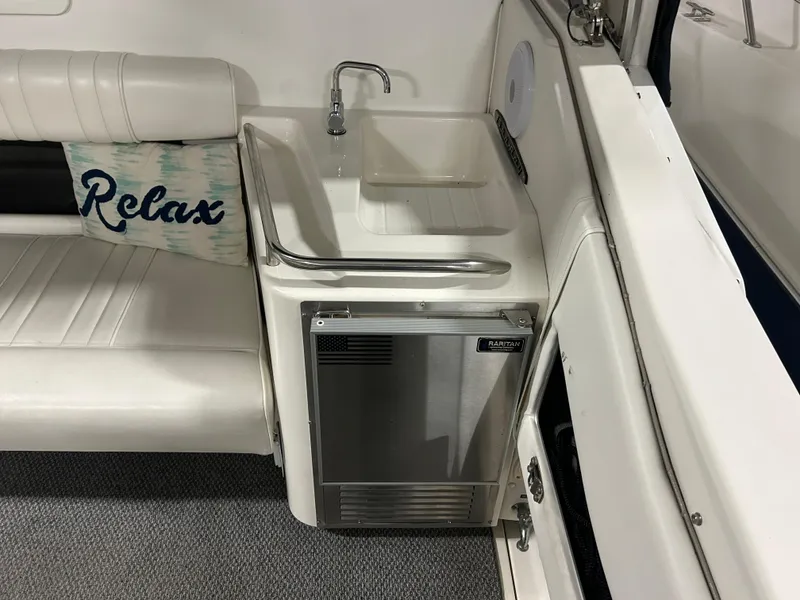 Slide: The Image of Interior of 1992 Sea Ray 370 Sundancer with sink, mini-fridge, and "Relax" pillow. - 9