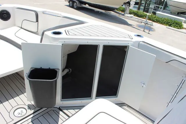 Slide: The Image of Yamaha Boats 2023 222 FSH Sport E storage area with trash bin. - 29