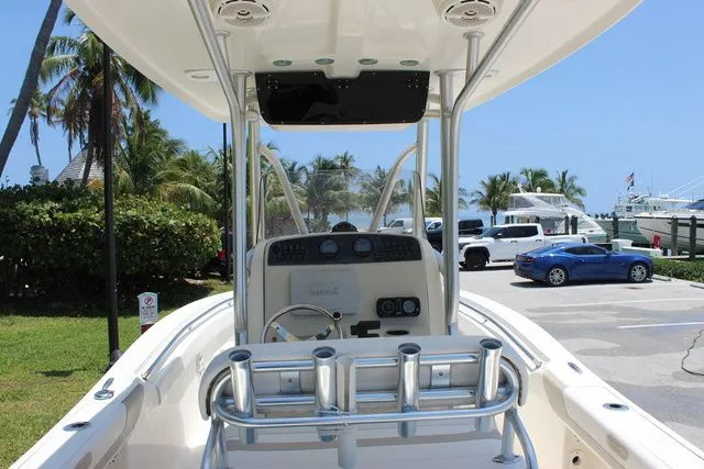 Slide: The Image of 2014 Pioneer 222 Sportfish boat docked with palm trees in the background. - 13