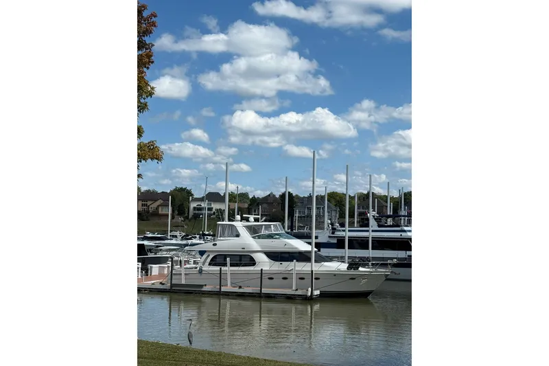 Slide: The Image of 2006 Carver 56 Voyager yacht docked at a marina under a blue sky. - 3