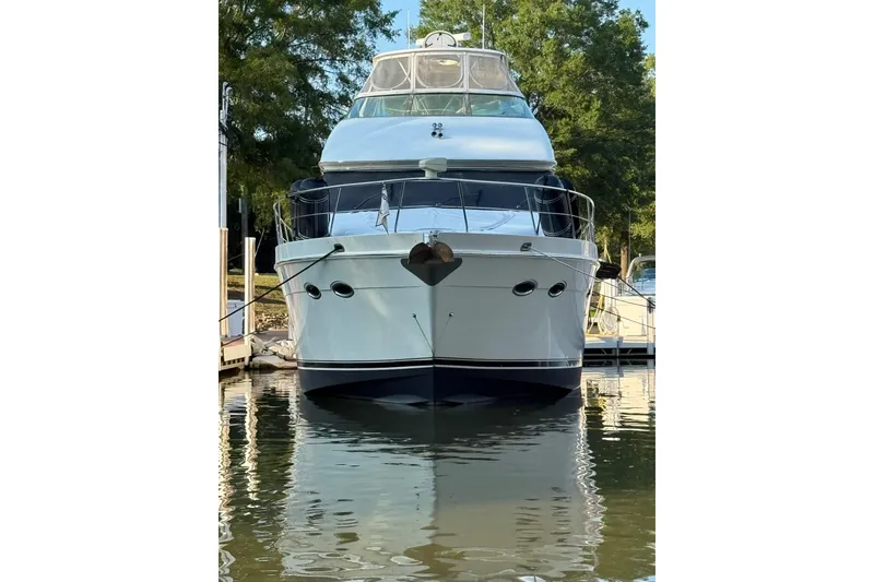 Slide: The Image of Front view of a 2006 Carver 56 Voyager yacht docked on calm water. - 4