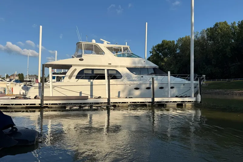 Slide: The Image of 2006 Carver 56 Voyager yacht docked at marina, clear sky, calm water. - 5