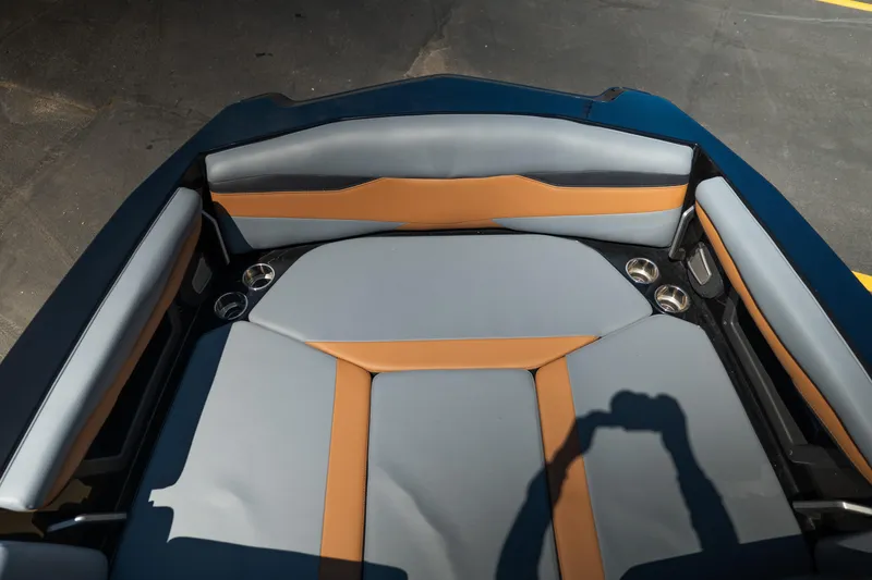 Slide: The Image of 2025 Axis A225 boat interior with gray and orange seating, cup holders visible. - 15