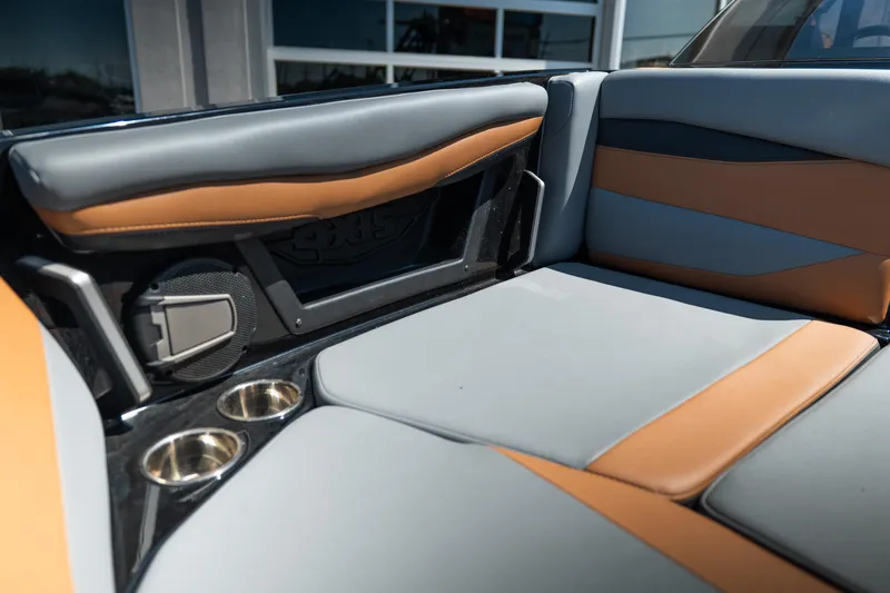Slide: The Image of 2025 Axis A225 boat interior with gray and tan seating, cup holders, and speaker. - 17