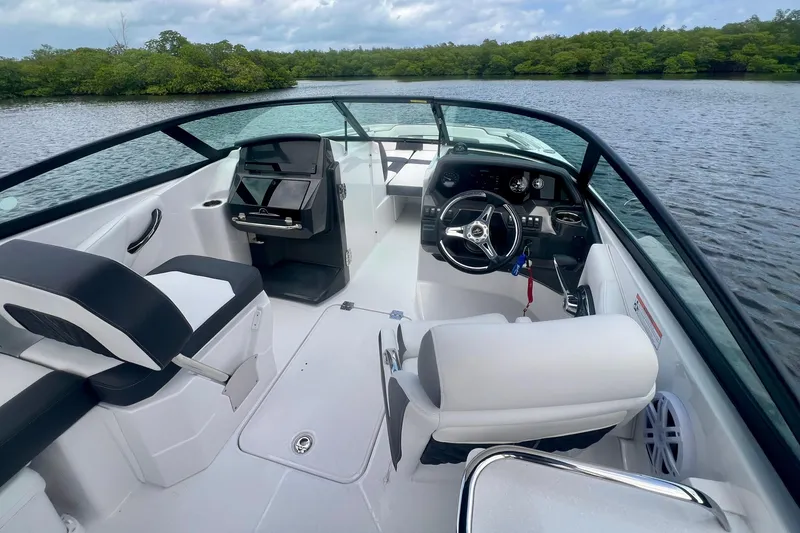 Slide: The Image of 2024 Monterey M-45 boat interior with sleek design, modern dashboard, and comfortable seating on a serene lake. - 10