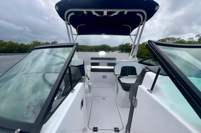 Slide: The Image of 2024 Monterey M-45 boat interior with open cockpit, sleek design, and scenic waterway view. - 12
