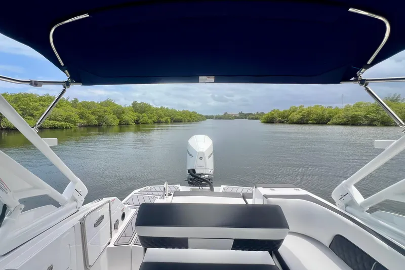 Slide: The Image of 2024 Monterey M-45 boat interior with canopy, overlooking serene waterway and lush greenery. - 17
